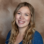 close-up portrait of Jordyn Olson-Bevins, Universal Banker in AbbyBank Medford branch, on a brown background
