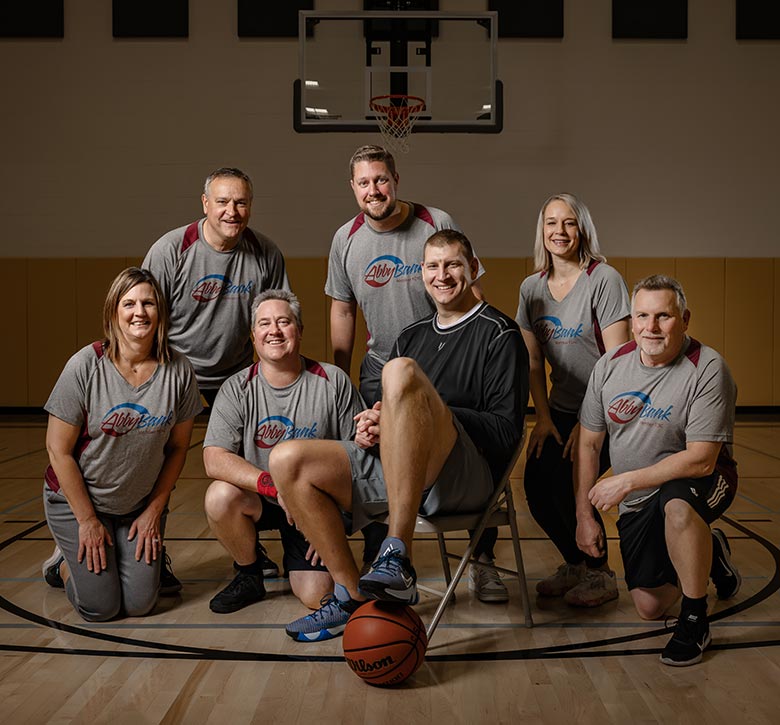 AbbyBank team pictured with Brian Butch on basketball court