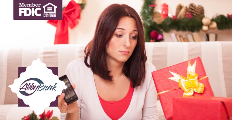 woman in front of couch with gift boxes for the holidays