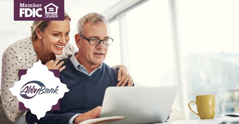 man and woman nearing retirement age looking at laptop with happy expressions