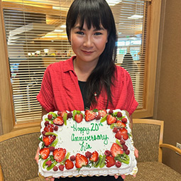 Lia Chang, Quality Control Program Assistant in Weston, holding a cake for her 20th work anniversary