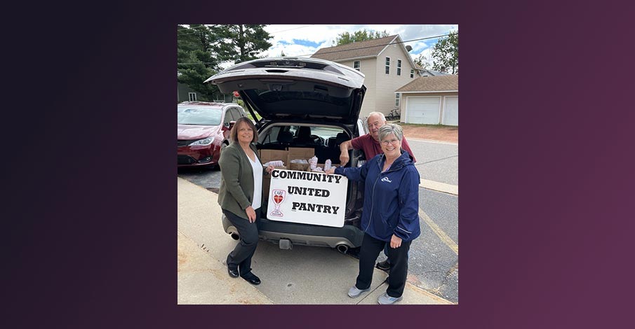 Teri and Karla from AbbyBank posing with CUP food pantry volunteer with van hatch door open full of hamburger